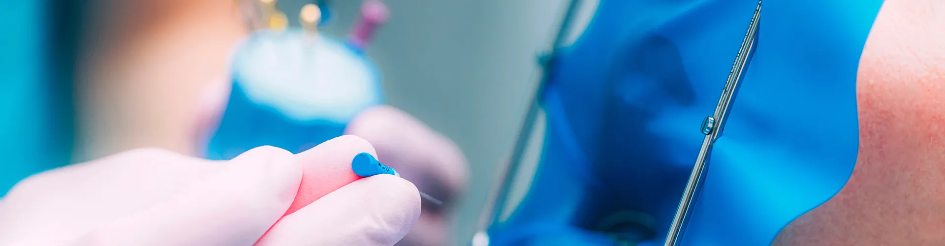 gloved hands holding dental tools by patient's mouth